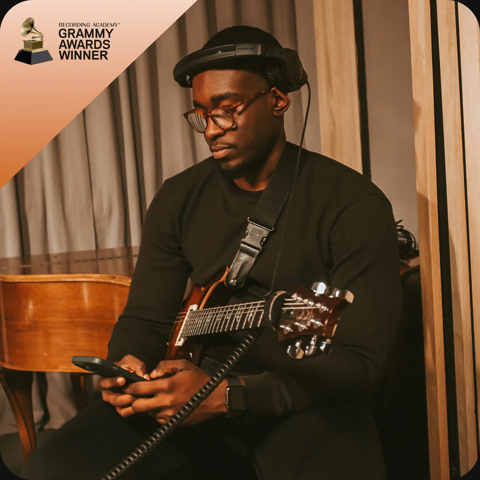 Kevin Ekofo in the studio with an acoustic guitar